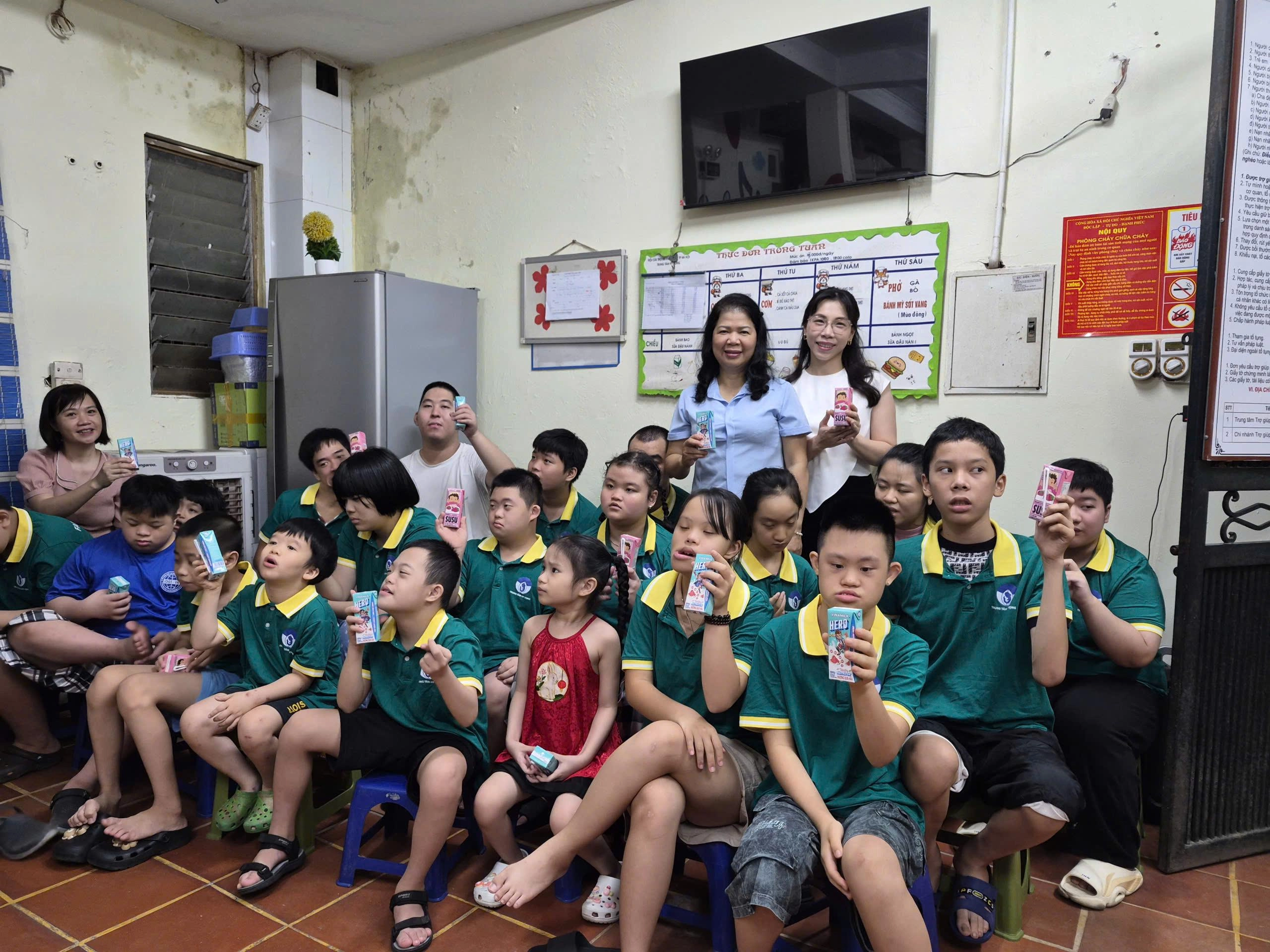 Bà Lê Tuyết Mai - Phó Chủ tịch Hội Bảo vệ quyền trẻ em Việt Nam cùng đại diện Vinamilk bên cạnh các em nhỏ tại Trung tâm Hy Vọng. 1790321932024_27959769727