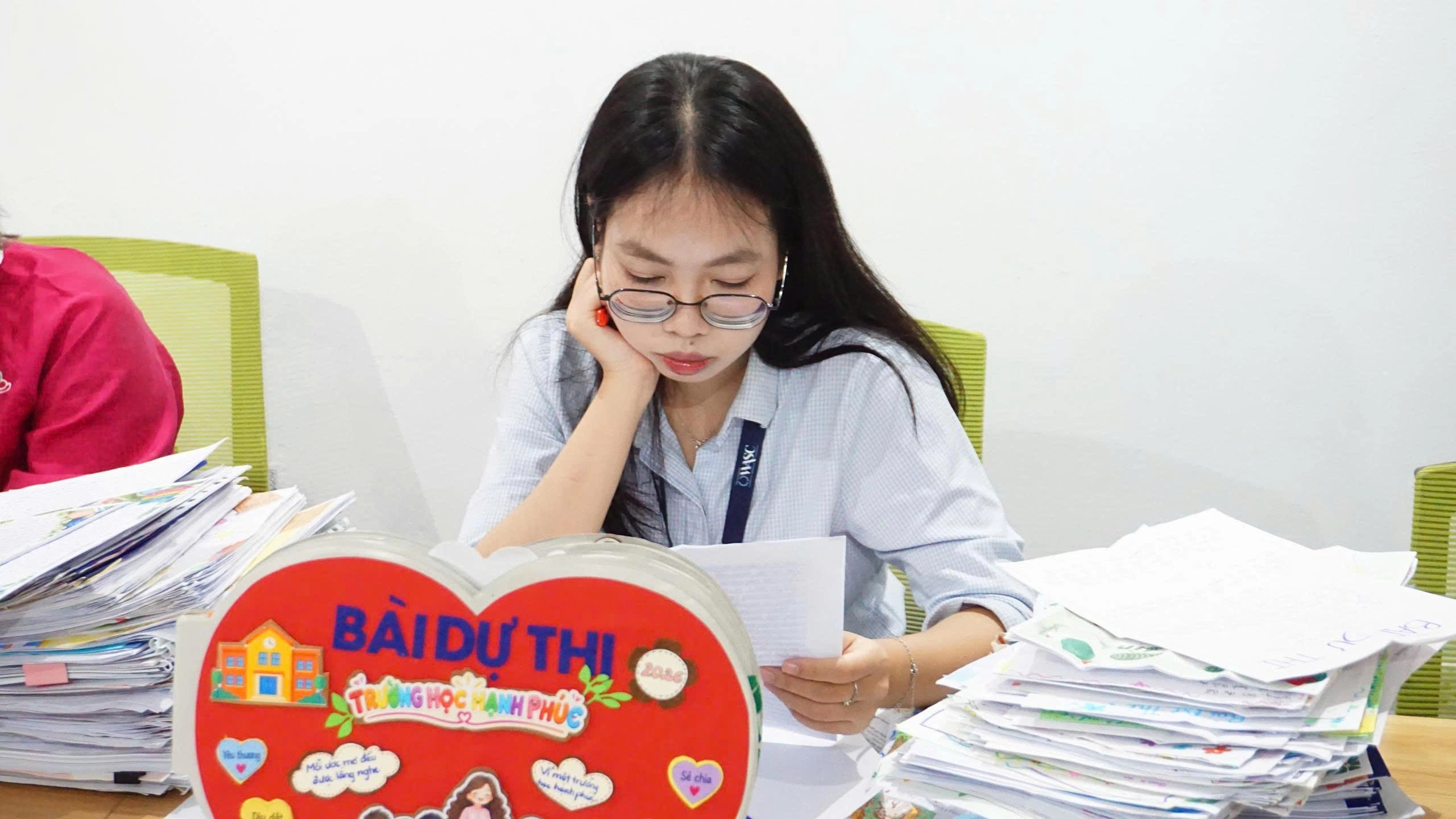 Cô Nguyễn Thị Ngọc Huyền, giáo viên Trường Phổ thông song ngữ quốc tế Wellspring Hanoi nghiên cứu các bài dự thi tại vòng sơ khảo Cuộc thi “Trường học hạnh phúc 2026” ngày 10/10. (Ảnh: Minh Hằng) trường học hạnh phúc