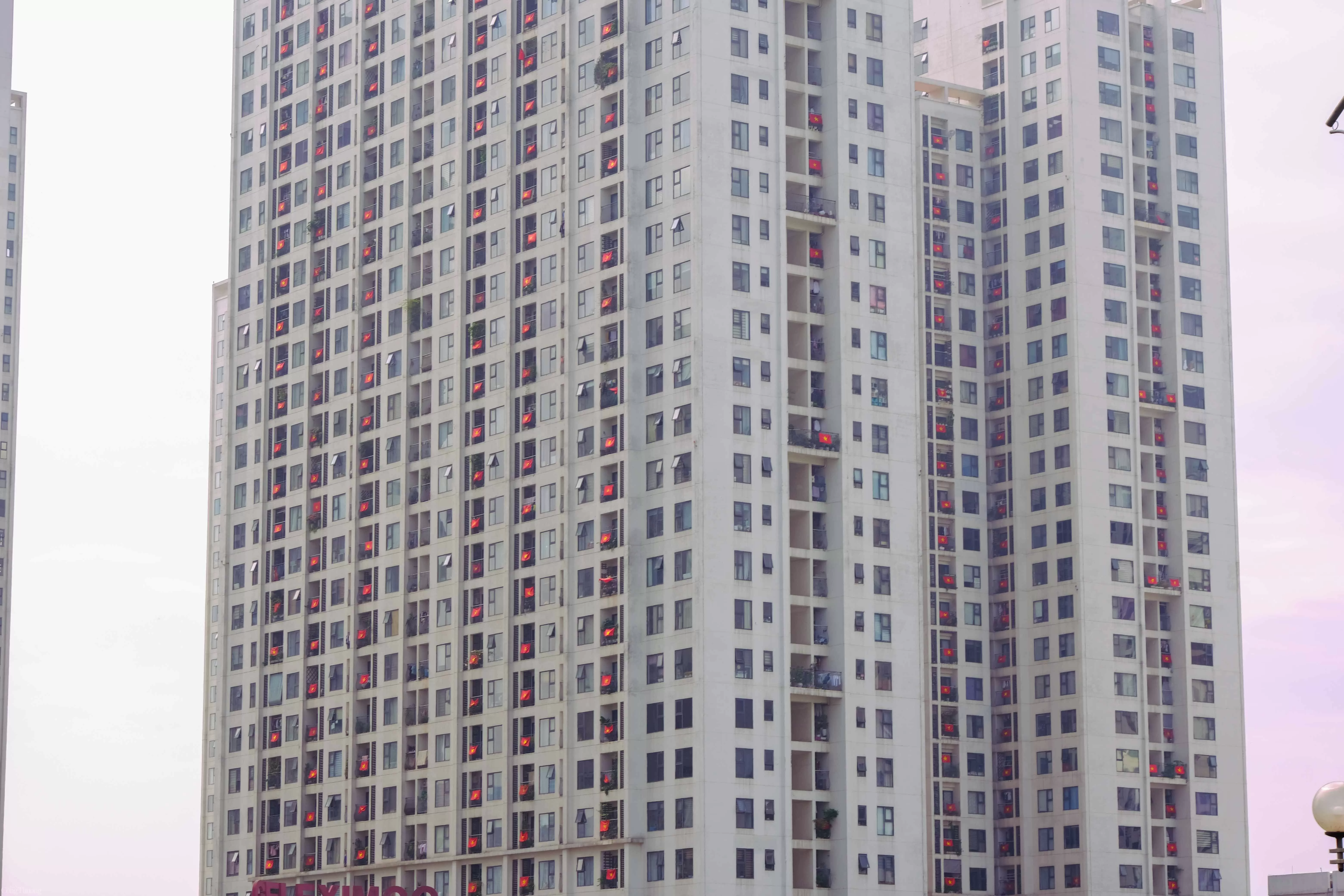 Giữa nhịp sống hiện đại với bao bộn bề, đâu đó trên những con phố quen, sắc đỏ rực rỡ của quốc kỳ lại lặng lẽ tung bay nơi ô cửa nhỏ, nơi ban công giản dị của mỗi mái nhà. Không lời hô vang, không lễ nghi rình rang, chỉ là một lá cờ được treo lên — như một nhịp đập thầm lặng của lòng yêu nước.