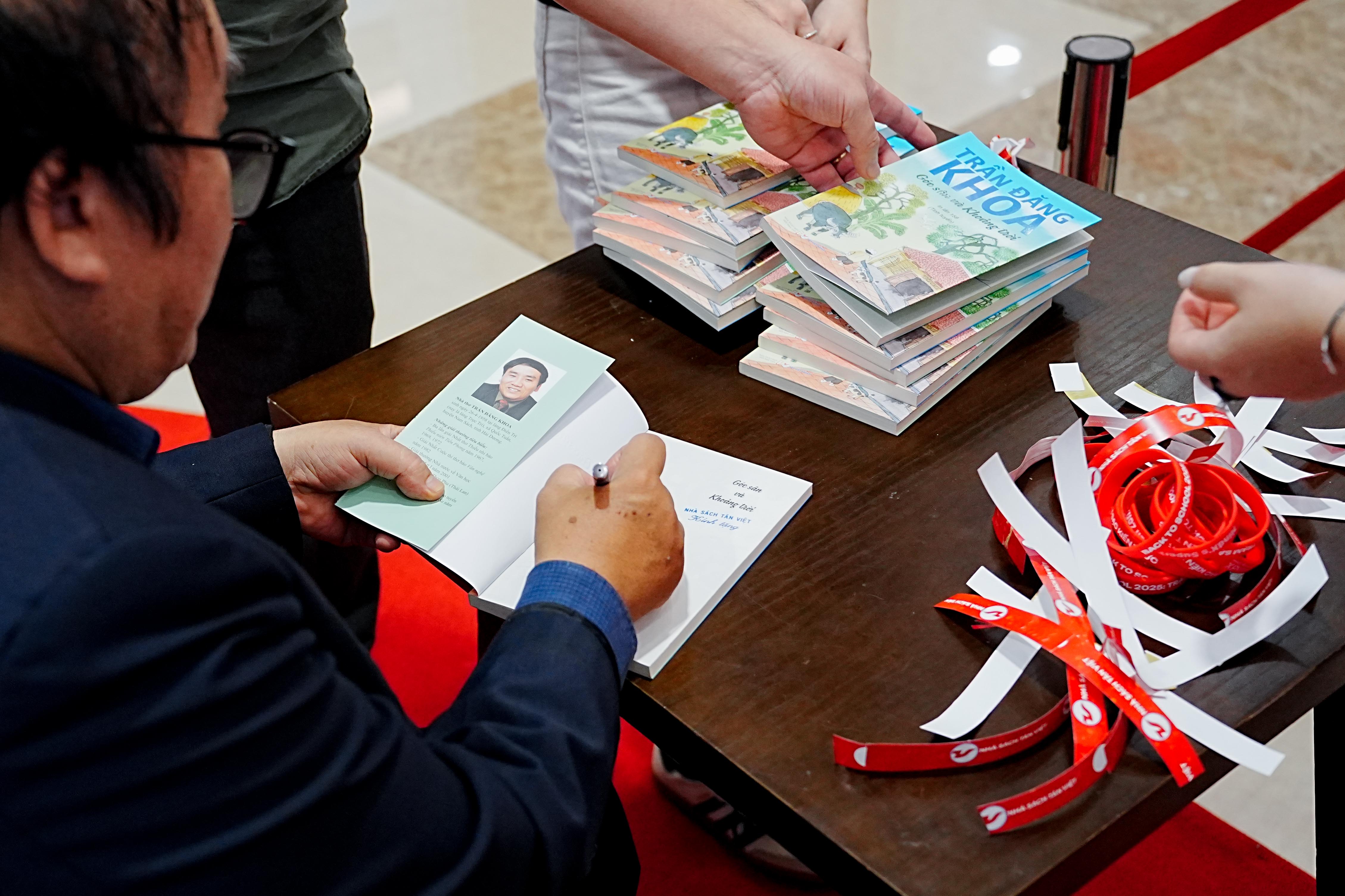 Nhà thơ Trần Đăng Khoa ký tặng tập thơ Góc sân và Khoảng trời cho độc giả. 51762858675.jpeg