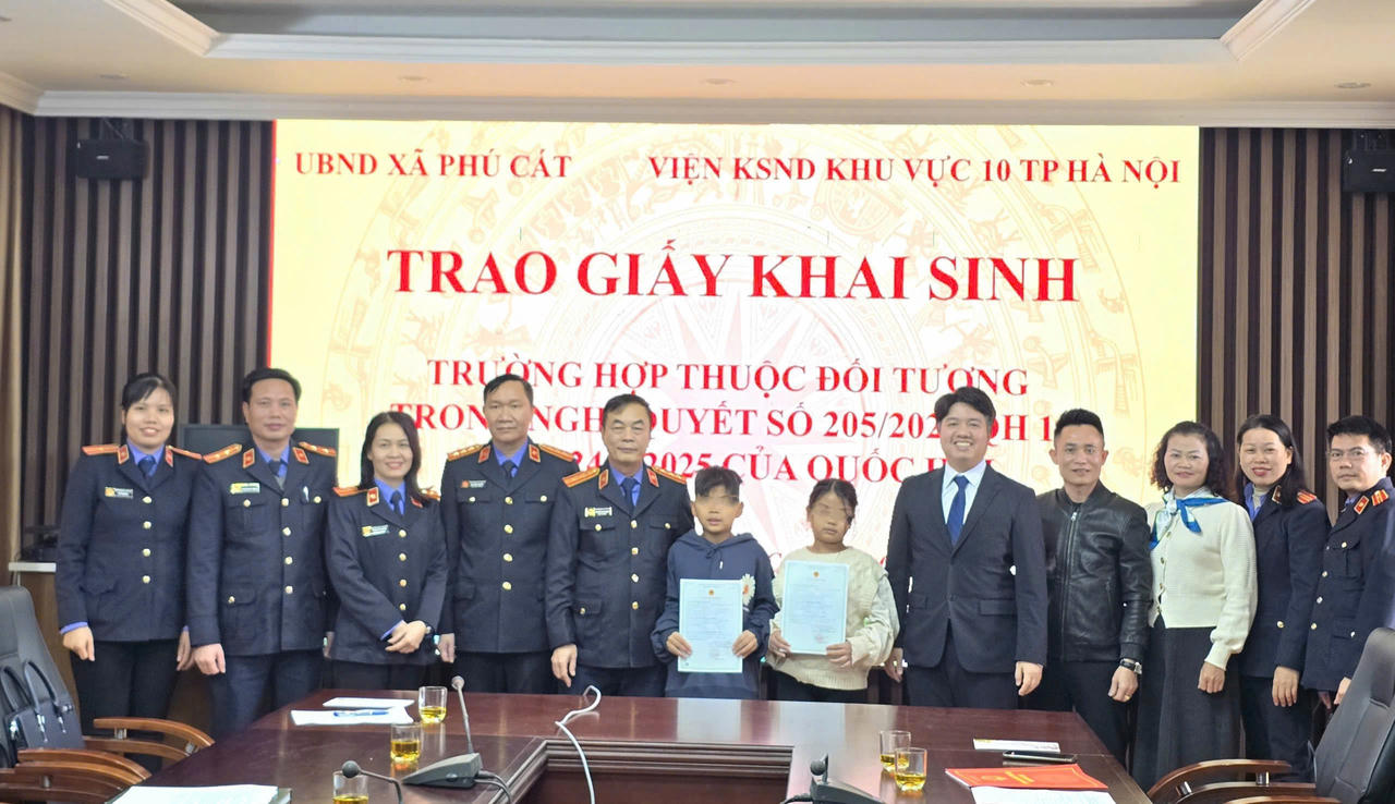 Lãnh đạo, cán bộ Viện KSND khu vực 10, UBND xã Phú Cát chụp ảnh lưu niệm với hai cháu tại buổi trao giấy khai sinh.