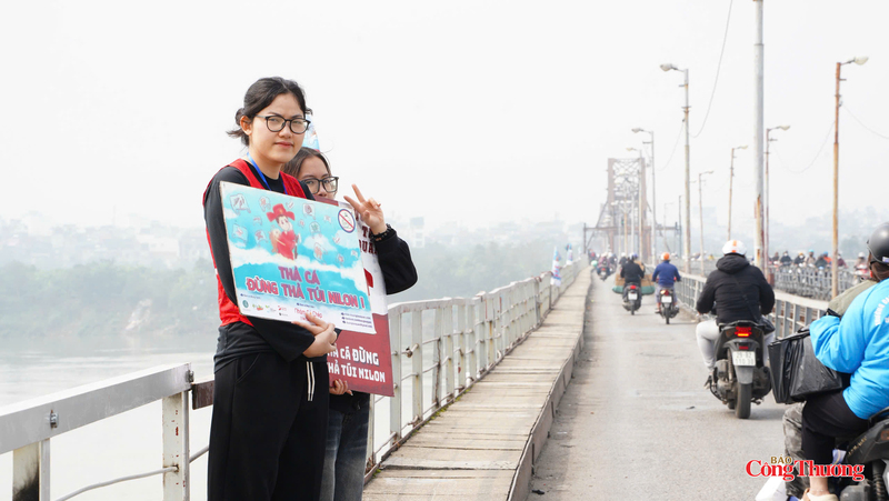 Các bạn trẻ giơ banner kêu gọi người dân “Thả cá đừng thả túi nilon” bảo vệ môi trường.