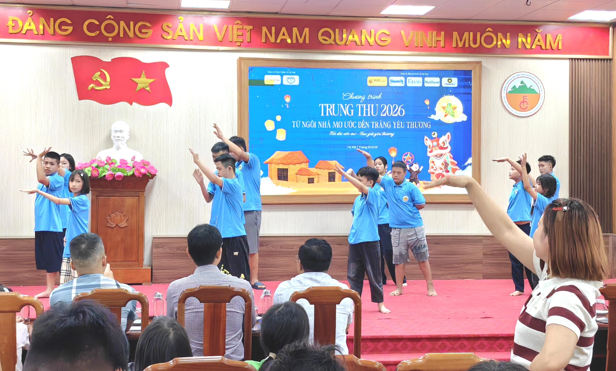 Cô giáo Đỗ Thu Trang (góc phải) lặng lẽ đứng dưới sân khấu, hướng dẫn từng động tác trong tiết mục văn nghệ của học sinh tự kỷ. IMG_20260917_093238_edit_40435307214417