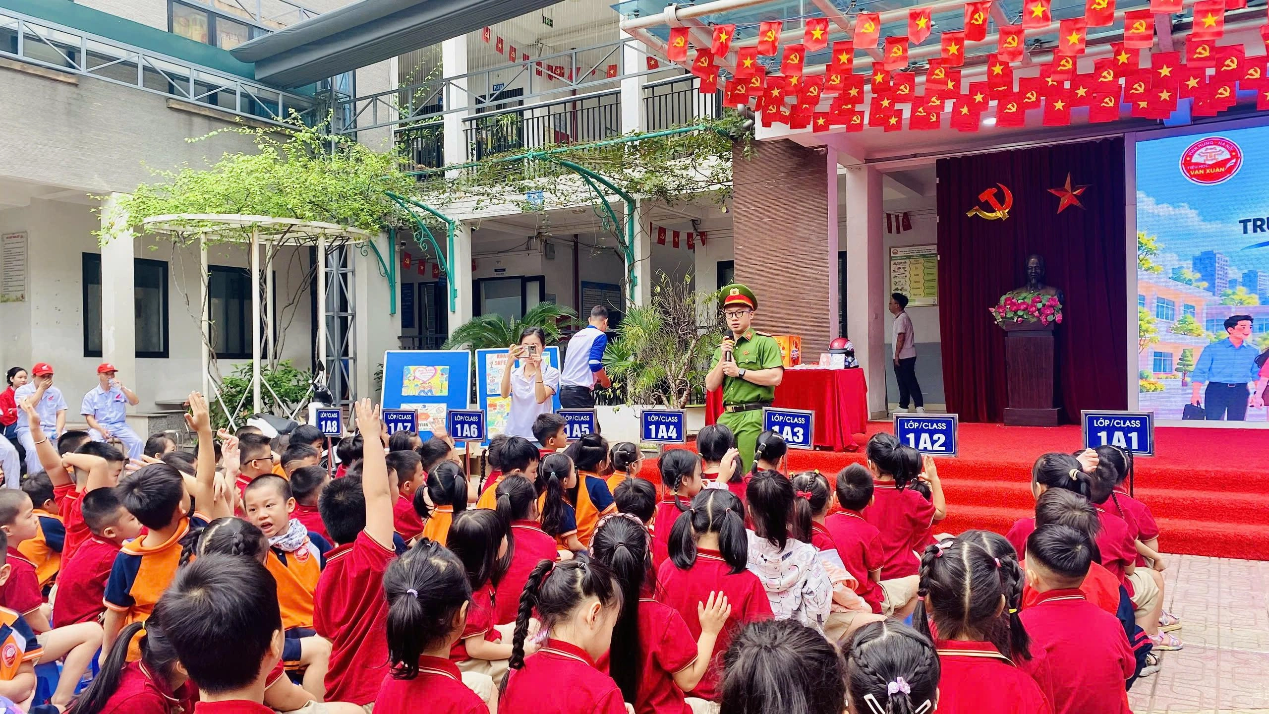 Thượng úy Vũ Hải Long, cán bộ tổ phòng chống tội phạm công an phường Vĩnh Hưng hướng dẫn các em học sinh kiến thức về an toàn giao thông vạn xuân 1