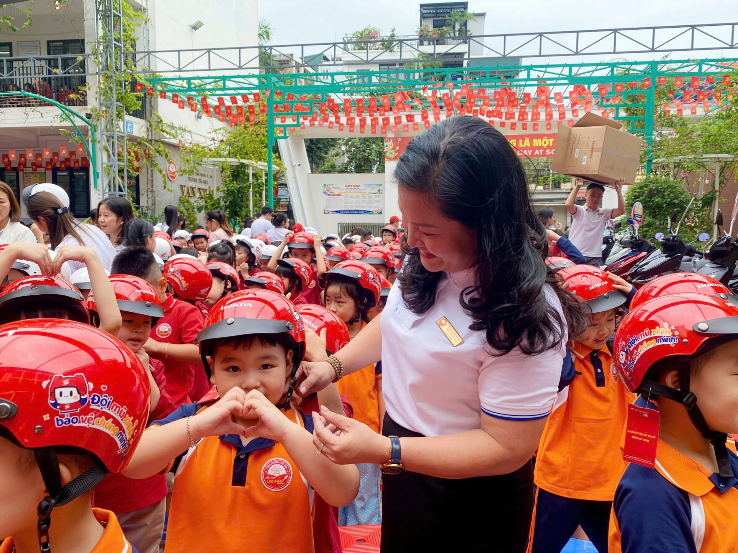 Nhà giáo Chử Thị Hồng Hạnh, Hiệu trưởng Tiểu học Vạn Xuân đeo mũ bảo hiểm cho học sinh vạn xuân 2