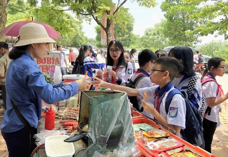 Những hàng ăn vặt gần nơi học luôn thu hút học sinh. Ảnh minh họa XIENQUE